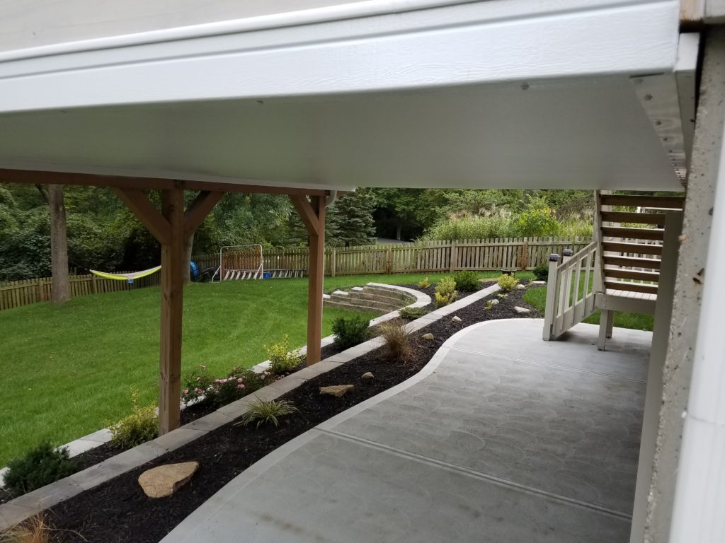A patio with a deck and garden area.